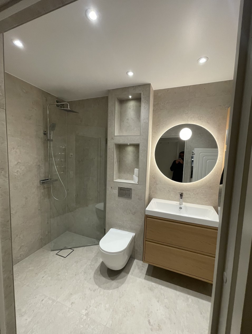 Finished bathroom in Majorna with walk-in shower, wall-hung WC, round backlit mirror and oak vanity